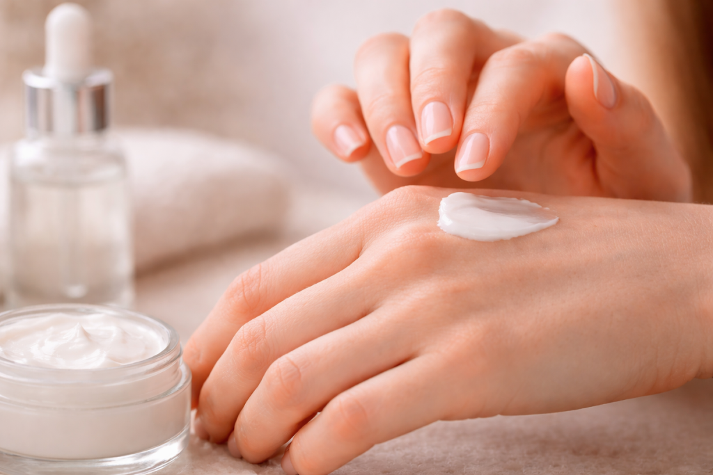 Weiße Creme auf dem Handrücken einer sehr gepflegten Hand.