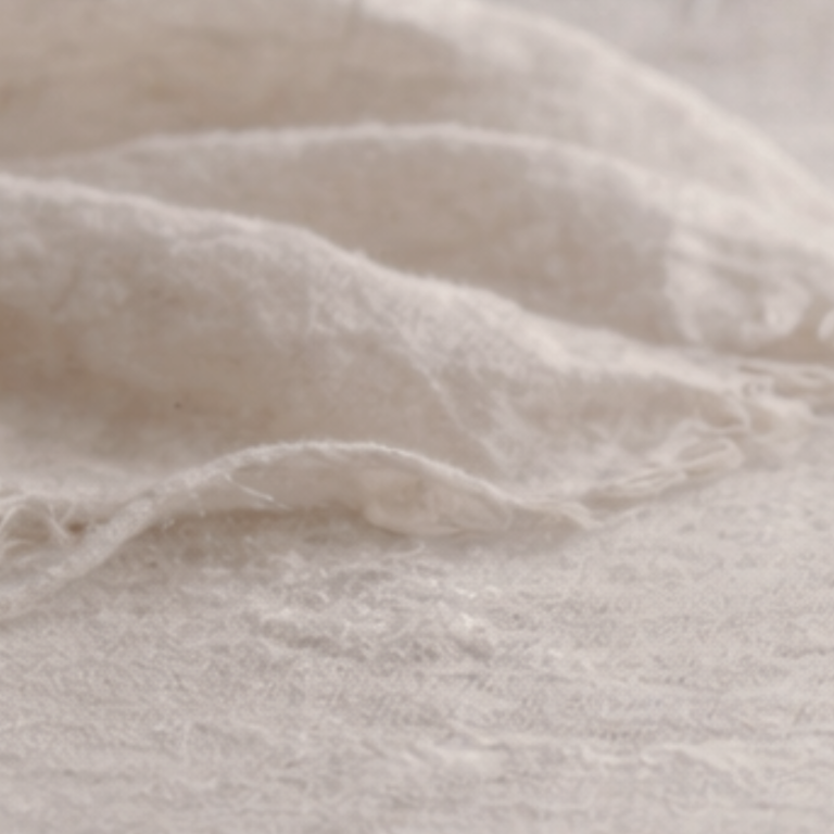 Junge Frau in einem Bademantel berührt nachdenklich ihr Gesicht.