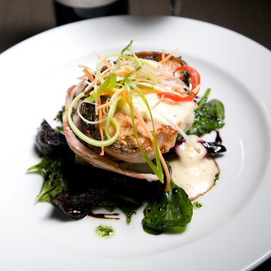 Ein schön angerichteter Teller mit Fisch, Gemüse und einer cremigen Sauce.